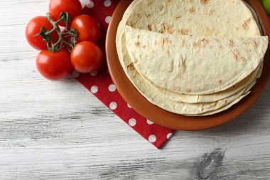ev yapımı kepekli un tortilla ve ahşap masa arka plan üzerinde plaka üzerinde sebze yığını