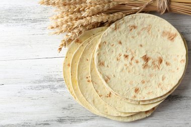 Tahta masa arkasında ev yapımı tam buğday unlu tortilla yığını