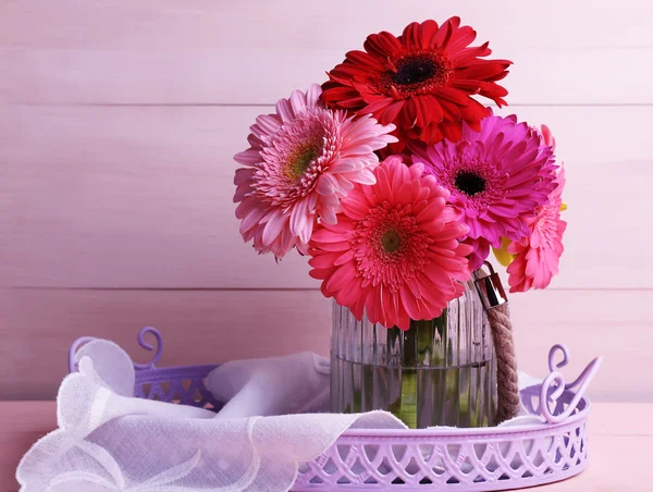 木製の背景の上に花瓶で美しい明るいガーベラ — ストック写真