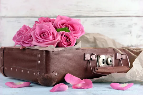 Piękne różowe róże w walizce, zbliżenie — Zdjęcie stockowe