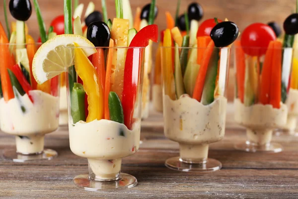 Lanche de verduras em artigos de vidro em mesa de madeira, close-up — Fotografia de Stock