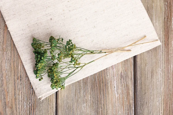 Bellissimi fiori secchi sul tovagliolo sul tavolo di legno da vicino — Foto Stock
