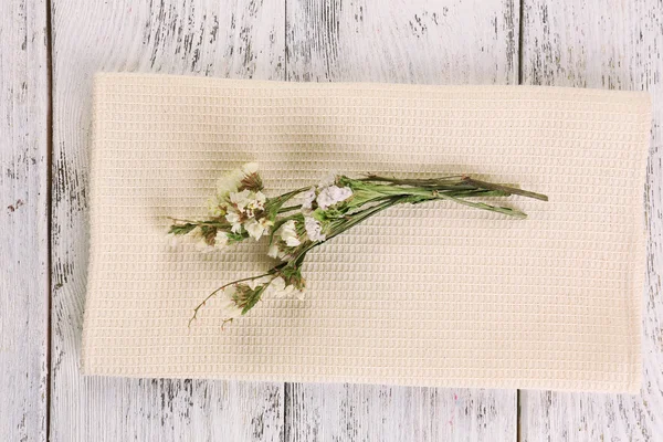 Mooie droge bloemen op servet op houten achtergrond — Stockfoto