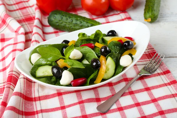 Ensalada de verduras frescas en tazón en la mesa de cerca —  Fotos de Stock