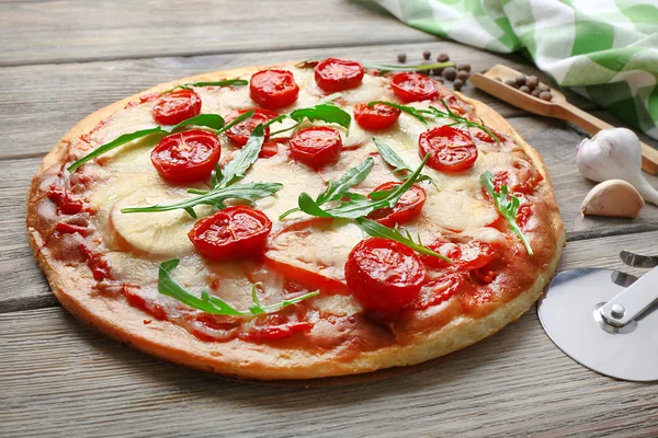 Deliciosa pizza com queijo e tomate cereja na mesa de madeira, close-up — Fotografia de Stock
