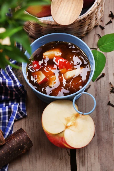 Marmellata di mele in secchio e mele rosse fresche sul tavolo di legno primo piano — Foto Stock