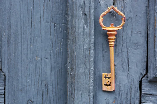 Oude sleutel op antieke houten deur close-up — Stockfoto