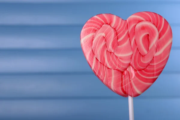Bright lollipop in shape of heart on wooden background — Stock Photo, Image