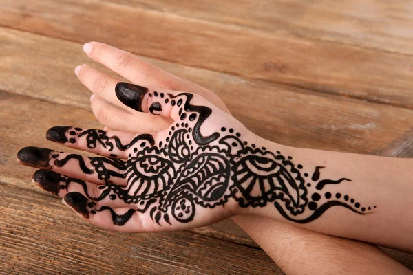 Mão pintada com henna sobre fundo de madeira — Fotografia de Stock