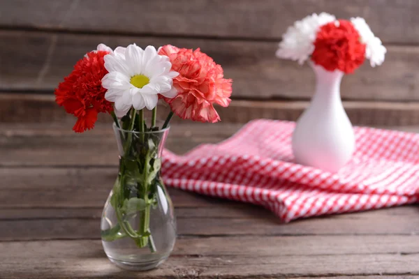 Mooie bloemen in vazen op tafel close-up — Stockfoto