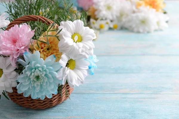 Bunte Chrysanthemen im Korb auf Holzgrund — Stockfoto