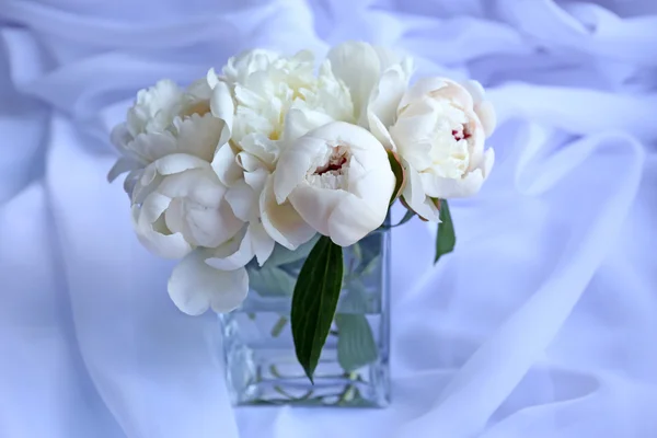 Beautiful white peonies in vase on fabric background — Stock Photo, Image