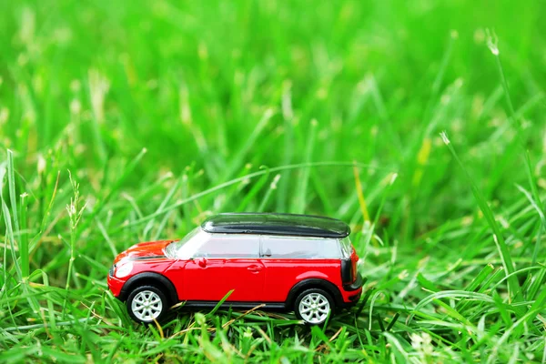 Small car model over green grass background — Stock Photo, Image