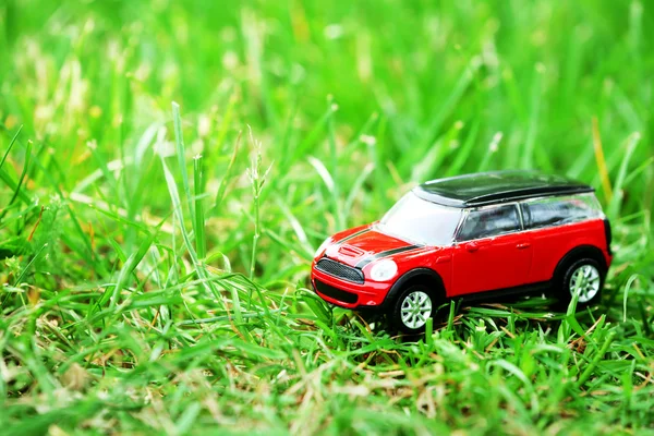 Modelo de coche pequeño sobre fondo de hierba verde —  Fotos de Stock