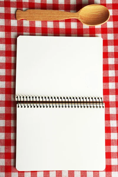 Open recipe book on color tablecloth background — Stock Photo, Image
