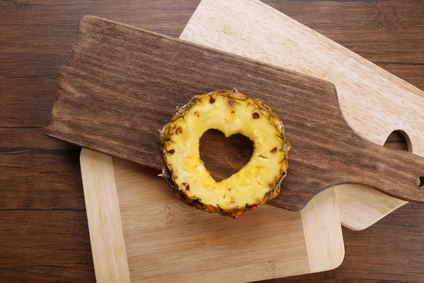 Ananas dilim ile ahşap arka plan üzerinde kalp şeklinde kesilmiş — Stok fotoğraf