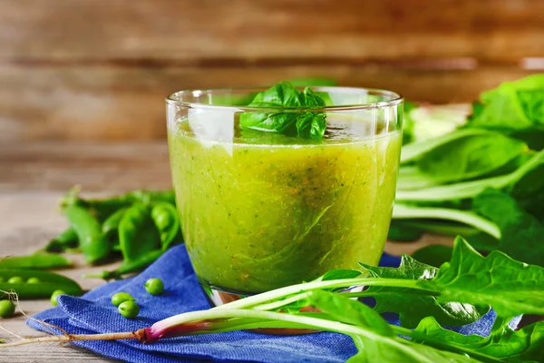 Gelas jus hijau sehat dengan bayam dan kacang polong di atas meja dekat — Stok Foto