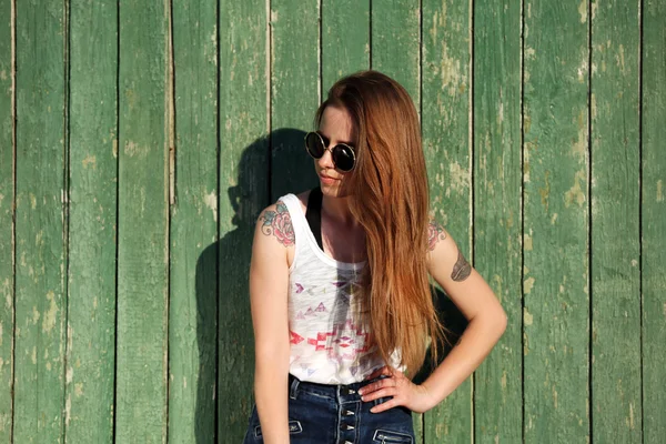 Krásná dívka s Tetovaný tělem na dřevěné stěně obrazce pozadí — Stock fotografie