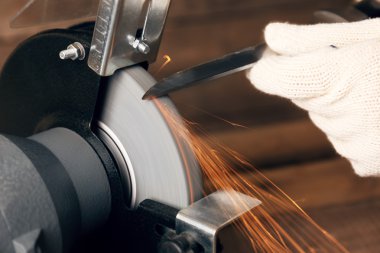 Bıçak bileyicisi ve bıçaklı bir el.