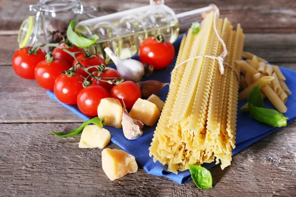 Pasta med körsbärstomater och andra ingredienser på träbord bakgrund — Stockfoto