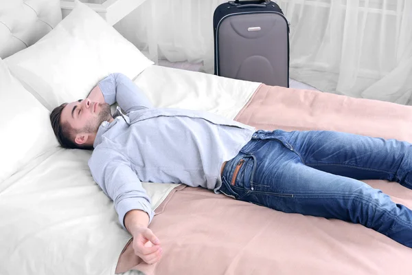 Hombre cansado descansando en la cama en la habitación — Foto de Stock