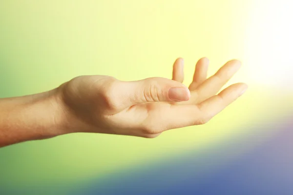 Vrouwelijke hand op kleurrijke achtergrond — Stockfoto