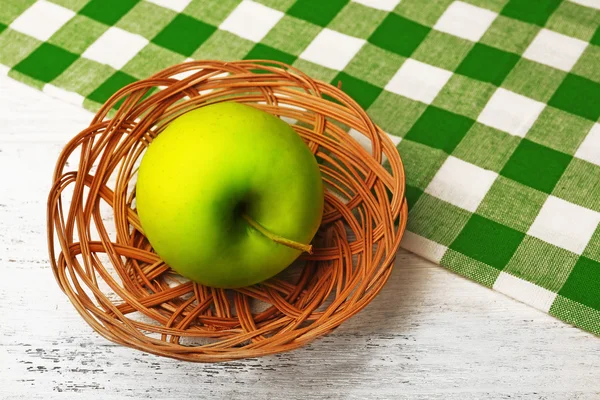 Apple v proutěném koši s ubrouskem na dřevěný stůl, záběr — Stock fotografie