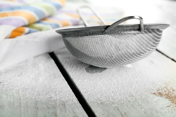 Sifting flour through sieve on wooden table, closeup — Stock Photo, Image