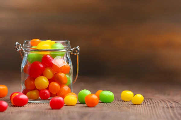 Coloridos caramelos en frasco sobre la mesa —  Fotos de Stock