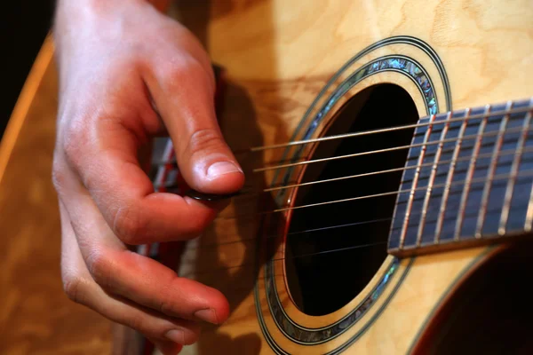 Young man playing on acoustic guitar — Stock Photo, Image
