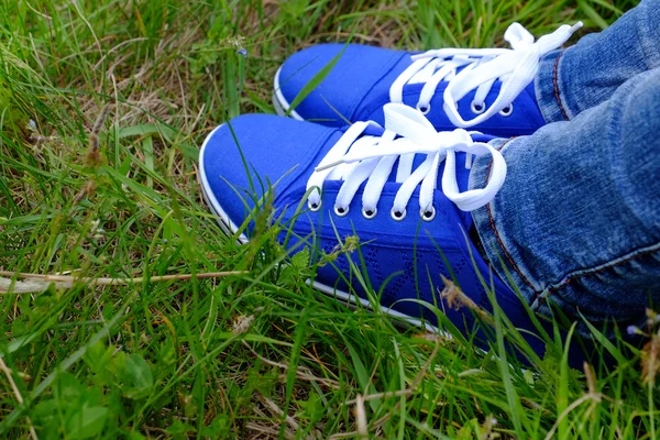Pies femeninos en zapatos de goma sobre fondo de hierba verde —  Fotos de Stock