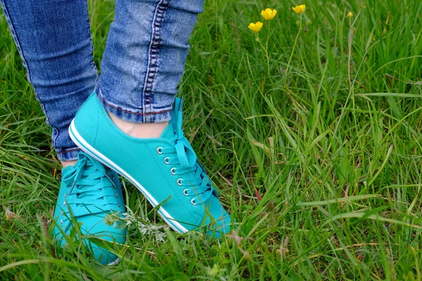 Pies femeninos en zapatos de goma sobre fondo de hierba verde —  Fotos de Stock