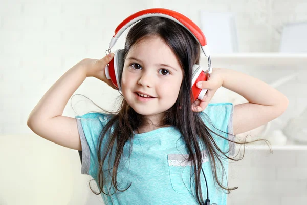 Vacker liten flicka lyssna på musik i rummet — Stockfoto