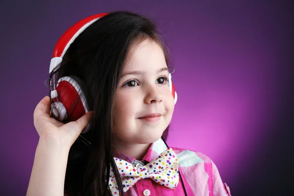 美しい少女は、色の背景に音楽を聴く — ストック写真