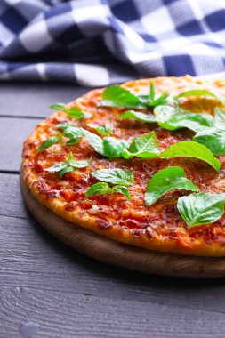 Pizza üzerinde ahşap masa, closeup fesleğen ile
