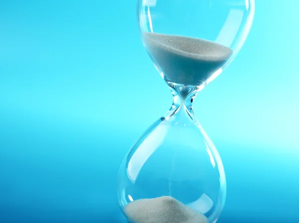 Hourglass on blue background — Stock Photo, Image