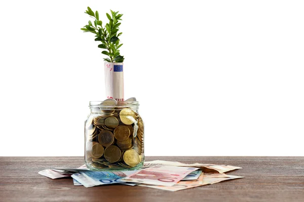 Money with growing sprout in glass jar on table isolated on white — Stock Photo, Image