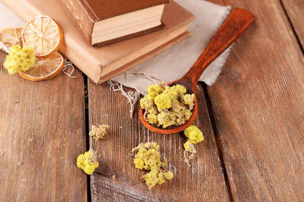 Oude boeken met droge bloemen en citroen op tafel close-up — Stockfoto