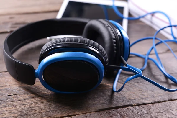 Auriculares con zapatillas y tablet sobre fondo de madera —  Fotos de Stock