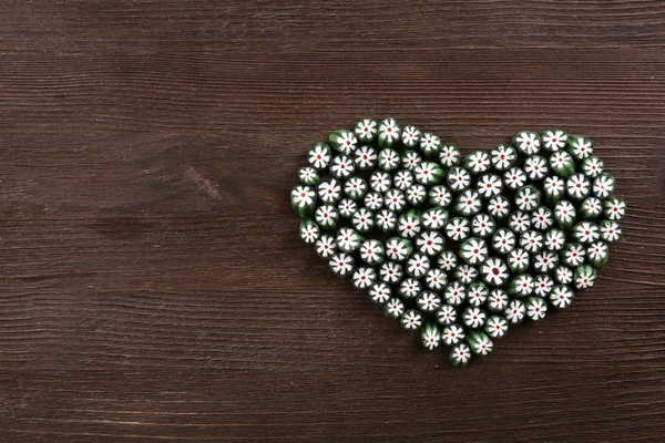 Солодкі цукерки у формі серця на дерев'яному фоні — стокове фото