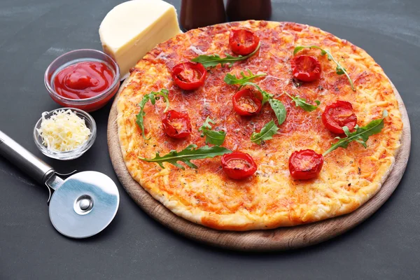 Pizza con rúcula y tomates cherry sobre fondo de mesa de madera —  Fotos de Stock