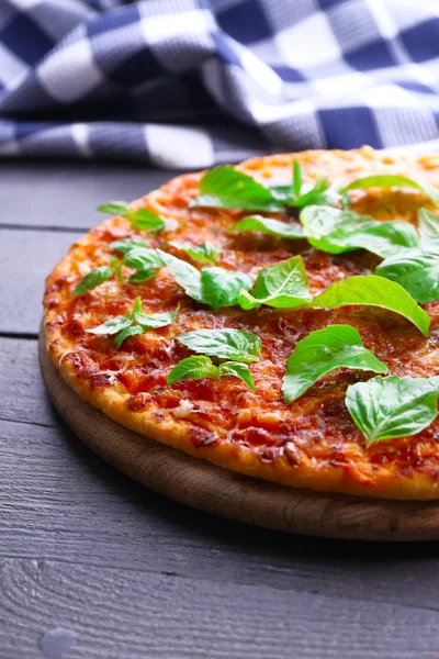 Pizza z bazylii na drewnianym stole, zbliżenie — Zdjęcie stockowe