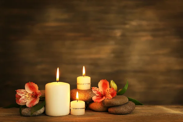 Bela composição com velas e pedras de spa em fundo de madeira — Fotografia de Stock