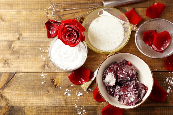 Making candied rose flower petals with egg whites and sugar, on wooden background — Stock Photo, Image