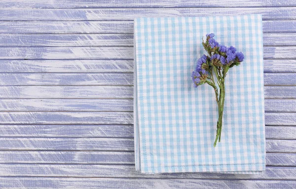 Mooie droge bloemen op servet op houten achtergrond — Stockfoto