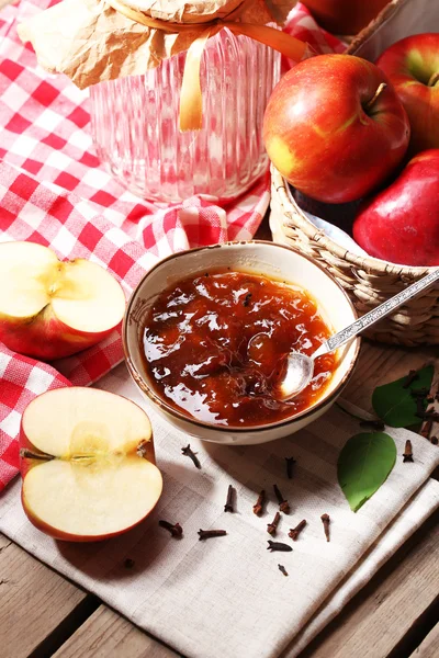 Apple jam en verse rode appels op houten tafel close-up — Stockfoto