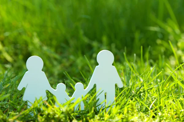 Cutout family over green grass background — Stock Photo, Image