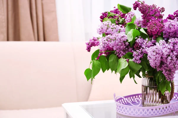 Schöne fliederfarbene Blumen in der Vase auf dem Tisch des Innenhintergrunds — Stockfoto