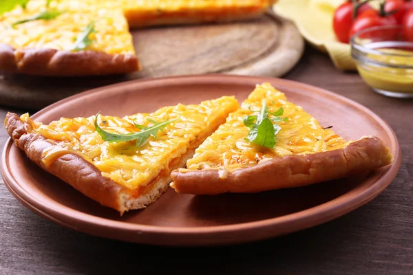 As partes de pizza de queijo saborosa com arugula e verduras na mesa fecham — Fotografia de Stock