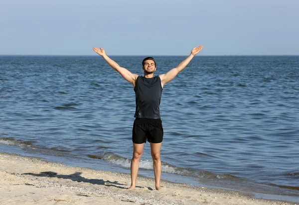Joven deportista haciendo ejercicio en la playa —  Fotos de Stock